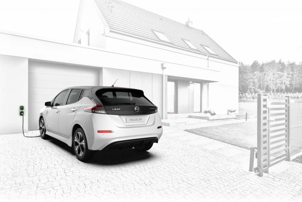 Electric car charging in a driveway.