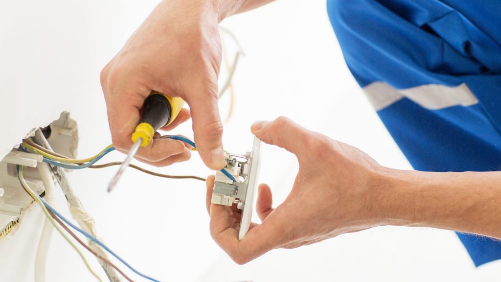 Electrician assembling a wall socket electrical plug